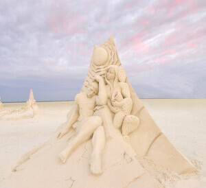 A stunning sand sculpture from the Fort Myers Beach Sand Sculpting Championship. A beautiful sunset is in the background.